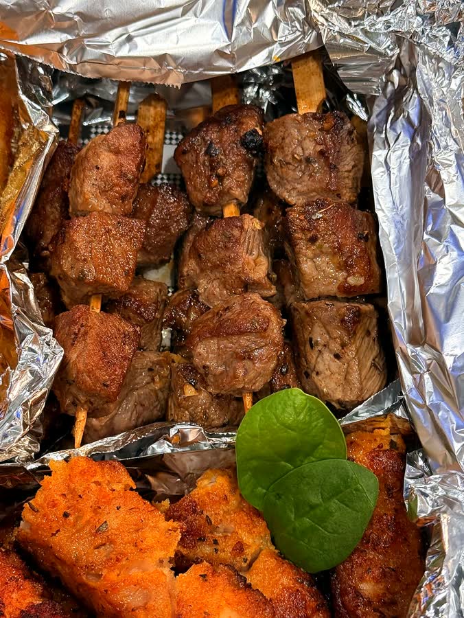 Grilled catering platter with skewers and croquettes