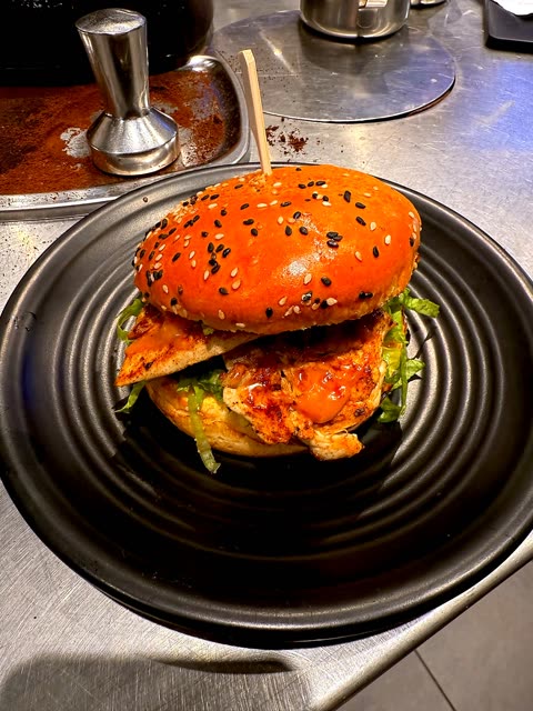 Grilled chicken burger on a black plate