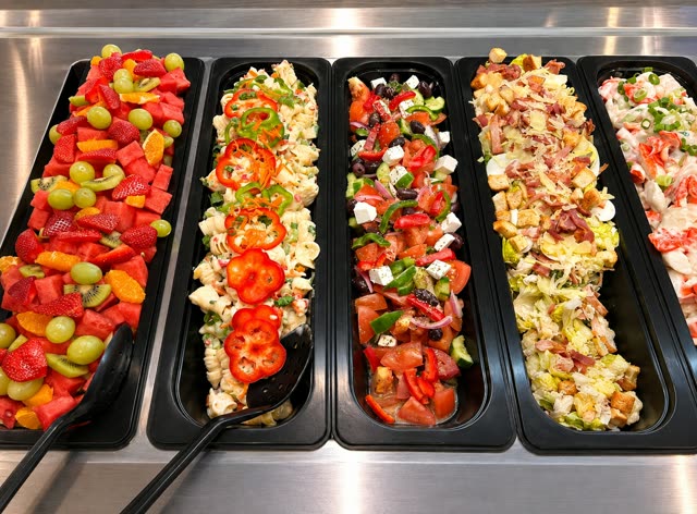 Fresh salad bar with fruit salad, pasta salad, Greek salad and Caesar